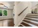 Open-concept entryway featuring hardwood floors, staircase, and views into the living room with ample natural light at 1053 Crane Ne Rd, Atlanta, GA 30324