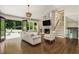 Open living room featuring a brick fireplace, hardwood floors, and doors to the outside patio at 1053 Crane Ne Rd, Atlanta, GA 30324