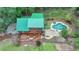 Overhead view of a log cabin featuring a green roof, wooden deck, pool, and serene wooded surroundings at 2864 Winder Hwy, Dacula, GA 30019