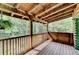 Relaxing back porch with wood railing, overhead covering and green trees in the background at 2864 Winder Hwy, Dacula, GA 30019