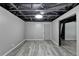 Finished basement area with new gray floors, modern lighting, painted walls, and an open layout, ideal for recreation at 2864 Winder Hwy, Dacula, GA 30019