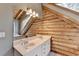 Bathroom featuring double sinks, large mirror, wood beams, and log wall at 2864 Winder Hwy, Dacula, GA 30019