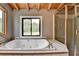 Bathroom with a jetted tub, and glass shower next to a large window showing nature at 2864 Winder Hwy, Dacula, GA 30019