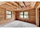 Bedroom featuring log walls, wood ceiling, and bright windows at 2864 Winder Hwy, Dacula, GA 30019