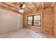 Cozy bedroom with wood walls, ceiling fan and outside view at 2864 Winder Hwy, Dacula, GA 30019