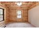 Bedroom with a wooden ceiling, wood siding, and windows with natural light at 2864 Winder Hwy, Dacula, GA 30019