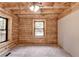 Bedroom featuring wood-paneled walls and ceiling with two windows at 2864 Winder Hwy, Dacula, GA 30019