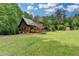 Charming log cabin home nestled in a lush green landscape, featuring a large yard at 2864 Winder Hwy, Dacula, GA 30019
