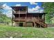 Exterior log home showcasing a multi-level deck and walkout basement on a lush green lawn at 2864 Winder Hwy, Dacula, GA 30019