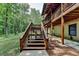 Exterior staircase leading to a multi-level deck of a log home surrounded by trees at 2864 Winder Hwy, Dacula, GA 30019