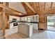 Spacious kitchen features wooden ceiling, white cabinets, black countertops and an island in the middle at 2864 Winder Hwy, Dacula, GA 30019