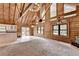 Open living room features log walls, wood beams, and an adjacent kitchen space at 2864 Winder Hwy, Dacula, GA 30019