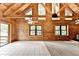 Spacious living room features log walls, wood beams, fireplace, and large windows at 2864 Winder Hwy, Dacula, GA 30019