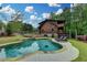 Private in-ground pool with stone patio, set against a backdrop of lush greenery and a charming log home at 2864 Winder Hwy, Dacula, GA 30019