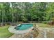 Secluded backyard pool area surrounded by lush landscaping and fencing, offering privacy and relaxation at 2864 Winder Hwy, Dacula, GA 30019
