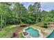 Aerial view of a kidney-shaped pool surrounded by a stone patio and lush greenery, creating a private oasis at 2864 Winder Hwy, Dacula, GA 30019