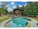 Private in-ground pool with stone patio, set against a backdrop of lush greenery and a charming log home at 2864 Winder Hwy, Dacula, GA 30019