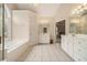 Bright bathroom featuring a garden tub, tile floor, double vanity sinks, and access to the main bedroom at 4045 Bonnett Creek Ln, Hoschton, GA 30548