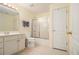 Bright bathroom with a single sink vanity, white cabinets, tile flooring, and shower with sliding glass doors at 4045 Bonnett Creek Ln, Hoschton, GA 30548