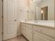 Bathroom featuring a single sink vanity with storage, a large mirror, and a neutral color palette at 4045 Bonnett Creek Ln, Hoschton, GA 30548