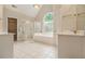 Bright bathroom with soaking tub, glass shower, double sinks, and tiled floors at 4045 Bonnett Creek Ln, Hoschton, GA 30548
