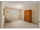 Bright bedroom features a cozy armchair, shuttered window, and wooden armoire at 4045 Bonnett Creek Ln, Hoschton, GA 30548