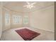 Expansive bedroom showcasing tray ceiling, multiple shuttered windows, and a stylish rug at 4045 Bonnett Creek Ln, Hoschton, GA 30548