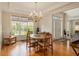 Bright dining room with a chandelier, hardwood floors, and large windows at 4045 Bonnett Creek Ln, Hoschton, GA 30548