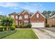 Beautiful two-story brick home with a well-manicured lawn and a two-car garage at 4045 Bonnett Creek Ln, Hoschton, GA 30548