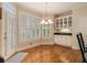 Bright kitchen nook featuring plantation shutters, hardwood floors, and classic white cabinetry with black countertops at 4045 Bonnett Creek Ln, Hoschton, GA 30548
