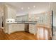 Open kitchen area with white cabinets, stainless steel appliances, black counters, hardwood floors, and bright breakfast nook at 4045 Bonnett Creek Ln, Hoschton, GA 30548