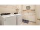 Functional laundry room with modern washer and dryer and built-in storage and sink at 4045 Bonnett Creek Ln, Hoschton, GA 30548