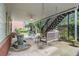 Covered patio with a swing, ceiling fan, water feature, and staircase to upper deck at 4045 Bonnett Creek Ln, Hoschton, GA 30548