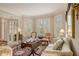 Cozy sitting room showcasing elegant seating, large windows and a dark accent rug at 4045 Bonnett Creek Ln, Hoschton, GA 30548