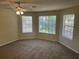 Bright bedroom with three windows offering backyard views and neutral carpet and walls at 1165 Oaks Pl, Stone Mountain, GA 30083
