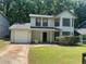 Charming two-story home with a manicured lawn and attached garage at 1165 Oaks Pl, Stone Mountain, GA 30083