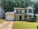 Charming two-story home with a well-maintained front lawn, attached garage, and neutral-colored exterior at 1165 Oaks Pl, Stone Mountain, GA 30083