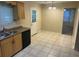 Functional kitchen featuring tile flooring, black appliances, and room for a small table at 1165 Oaks Pl, Stone Mountain, GA 30083