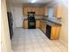 Functional kitchen featuring tile flooring, black appliances, and ample cabinet space at 1165 Oaks Pl, Stone Mountain, GA 30083