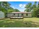 Backyard view of the home featuring a small deck, grassy yard, and mature trees at 1824 Atherton Dr, Decatur, GA 30035