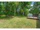 Backyard showing a wooden deck, grass, and wooded area at the property line at 1824 Atherton Dr, Decatur, GA 30035