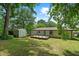 Backyard view with a small deck, shed, grassy yard, and mature trees on a sunny day at 1824 Atherton Dr, Decatur, GA 30035