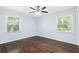 Bedroom showcasing hardwood floors, blue walls, two windows, and a ceiling fan at 1824 Atherton Dr, Decatur, GA 30035