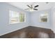 Bright bedroom featuring hardwood floors, blue walls, two windows, a ceiling fan, and a closet at 1824 Atherton Dr, Decatur, GA 30035
