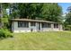 Charming single-story home with well-maintained lawn, painted white brick, contrasting trim and a blue front door at 1824 Atherton Dr, Decatur, GA 30035