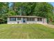 Charming single-story home with well-maintained lawn, painted white brick, contrasting trim and a blue front door at 1824 Atherton Dr, Decatur, GA 30035