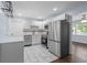 Modern kitchen with stainless steel appliances, white cabinets, stone countertops, and elegant marble tile flooring at 1824 Atherton Dr, Decatur, GA 30035