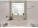 Bright bathroom featuring a soaking tub with jets and decorative accents under a frosted window at 2707 Mariner Way, Villa Rica, GA 30180