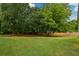 Expansive, lush backyard featuring mature trees and a well-maintained lawn, perfect for outdoor activities at 3217 New Rutledge Nw Rd, Kennesaw, GA 30152
