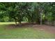 Shaded backyard space with mature trees and a well-maintained lawn, creating a peaceful outdoor setting at 3217 New Rutledge Nw Rd, Kennesaw, GA 30152